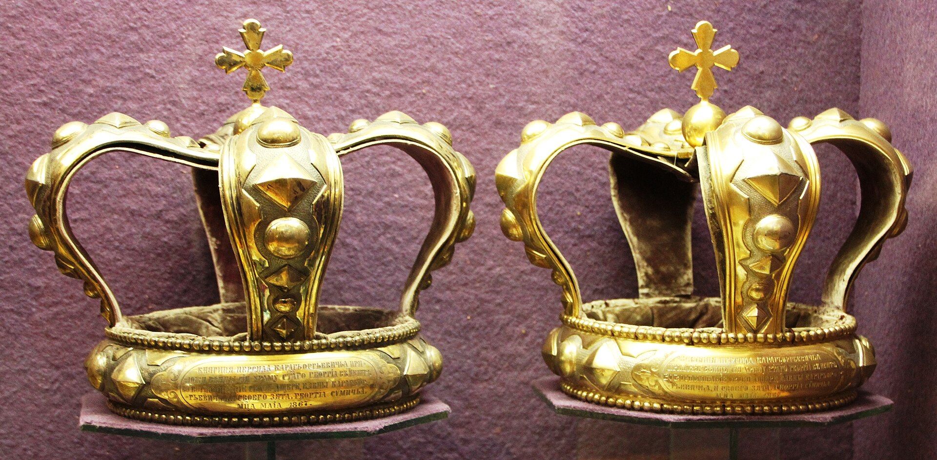 A pair of ornate historic Orthodox wedding crowns displayed side by side